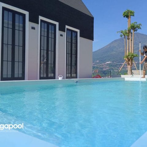 Petugas membersihkan kolam renang yang airnya berubah hijau