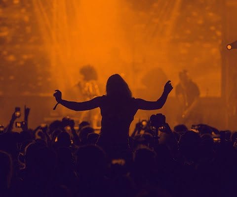 Suasana konser musik dangdut Indonesia dengan penyanyi dan penonton yang meriah