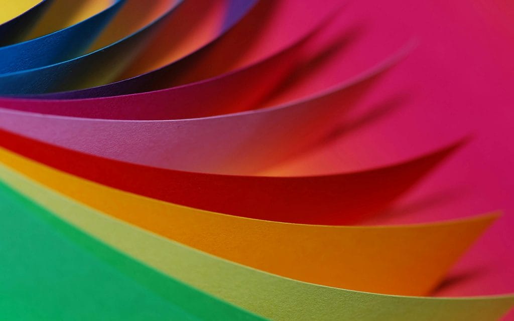 Close up lembaran kertas berwarna-warni sebagai ilustrasi konsep color photography dalam seni fotografi
