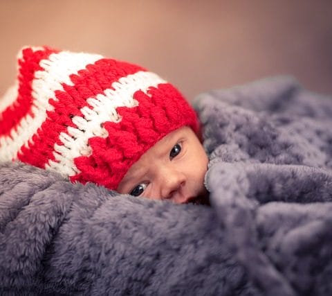 Bayi berbaring di atas selimut lembut saat sesi newborn photography