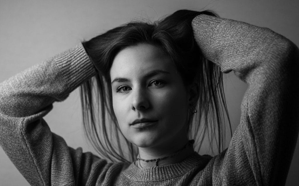 Potret hitam putih seseorang dengan pencahayaan gaya Rembrandt, menampilkan segitiga cahaya di pipi dan bayangan lembut di sisi wajah, menciptakan efek dramatis dan klasik dalam fotografi potret