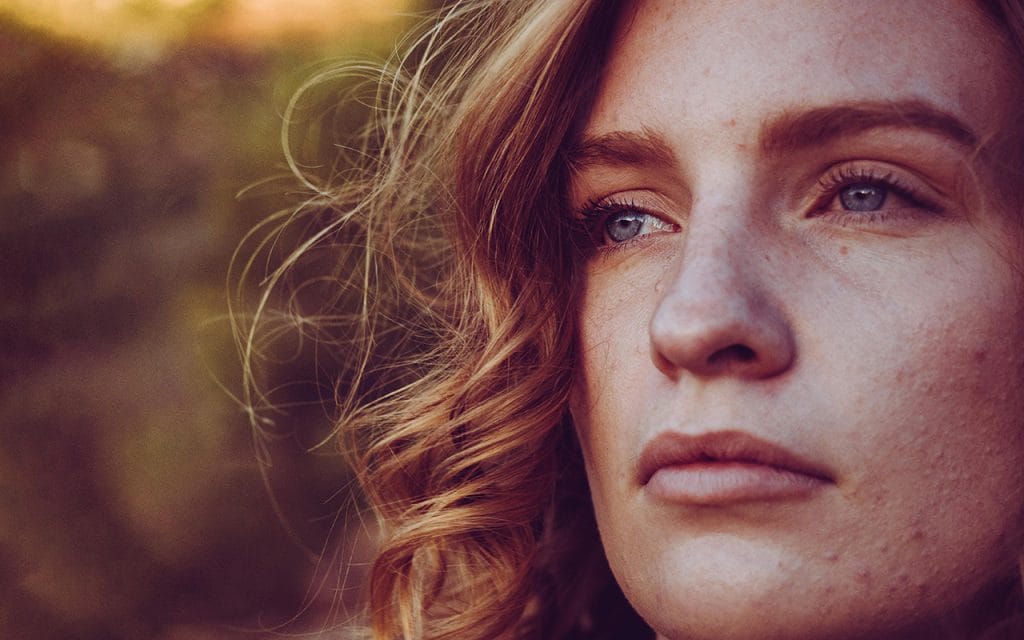 Foto close up wajah seseorang dengan ekspresi tenang dan detail tekstur kulit terlihat jelas, contoh teknik close up dalam fotografi