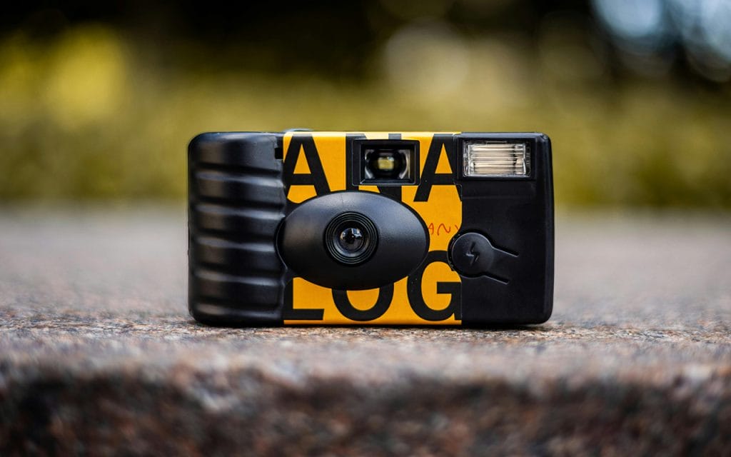 Kamera sekali pakai berwarna hitam kuning dengan lensa dan flash, contoh disposable camera untuk traveling