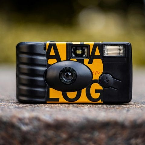 Kamera sekali pakai berwarna hitam kuning dengan lensa dan flash, contoh disposable camera untuk traveling
