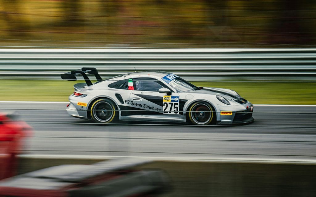 Foto mobil balap dengan teknik panning, objek terlihat tajam sementara latar belakang blur untuk menunjukkan efek gerakan