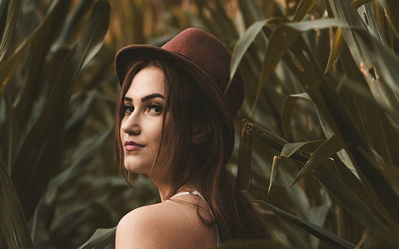 Foto portrait natural perempuan dengan latar belakang pepohonan menggunakan kamera HP