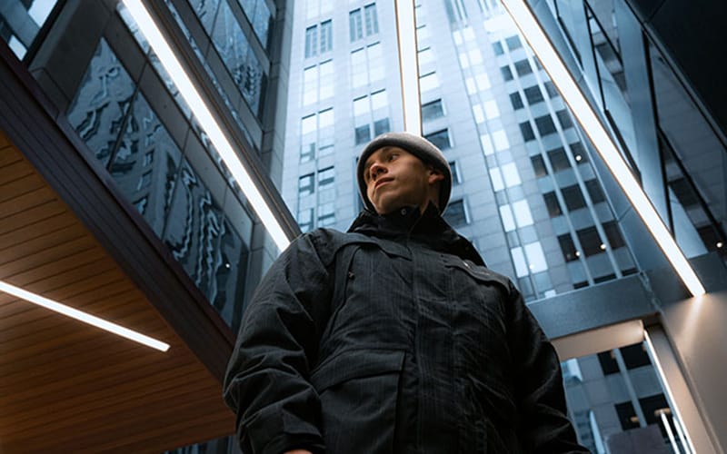 Foto pria dengan latar gedung tinggi diambil dari sudut rendah, contoh teknik low angle dalam fotografi