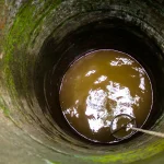 Bagian dalam sumur dengan air tanah dan dinding berlumut